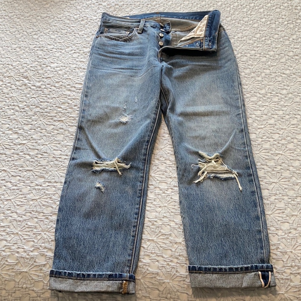 High-waisted button-fly jeans with ripped knees